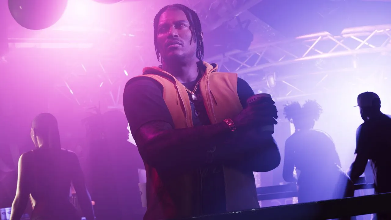 Dre'Quan Priest official artwork from the GTA VI website - Dre'Quan in a club, crossing his arms with a drink in his hand